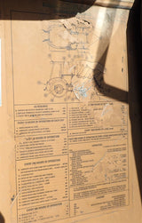 Technical drawing or blueprint on a cardboard surface with visible wear.