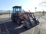 Case backhoe loader on a paved surface with a clear sky