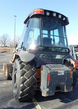 Skid steer loader in a parking lot with clear sky