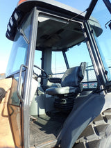 Close-up of a tractor's driver's seat and dashboard with a clear sky background
